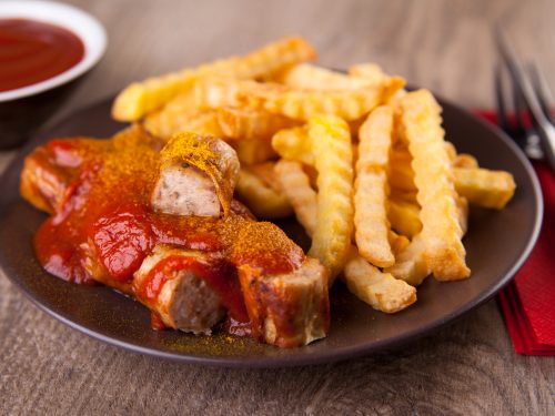 Currywurst is a sausage in slices and surrounded by Sweet Curry ketchup usually sprinkled with Curry powder